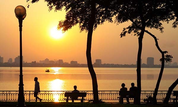 Photo of people relaxing by the lake in sunset afternoon